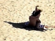 Hidden cam scene with a couple banging in the cowgirl pose on a beach
